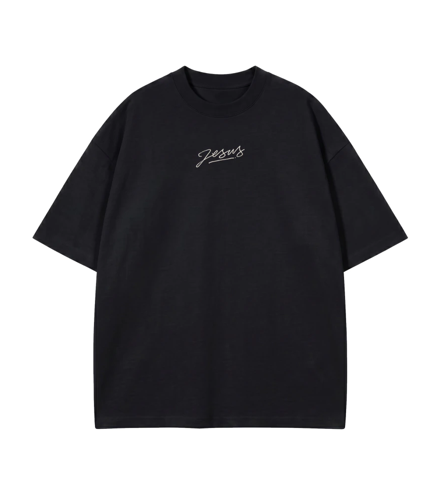Camiseta Oversized All The World Needs Is Jesus preta — vista de frente com assinatura Jesus